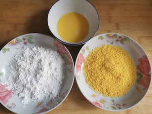 用一个盘子放淀粉,一个盘子放面包屑,然后在碗里打鸡蛋