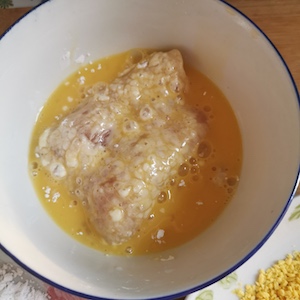 将涂有淀粉的鸡肉浸入鸡蛋中