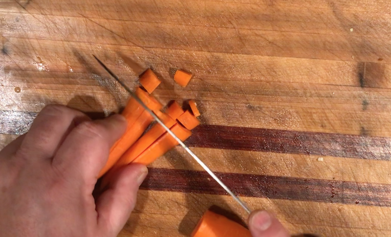 Chop across the sticks to dice the carrots