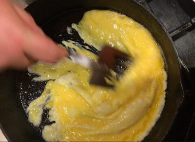 Push eggs to far side of pan