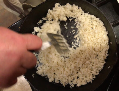 Stir-fry rice rapidly over high heat until rice begins to sizzle and pop. Goal is to heat the rice evenly