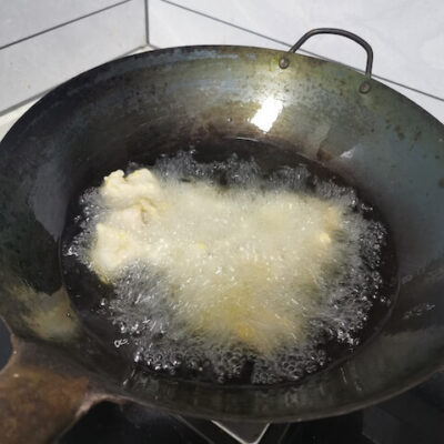 Fry the coated pork in hot oil