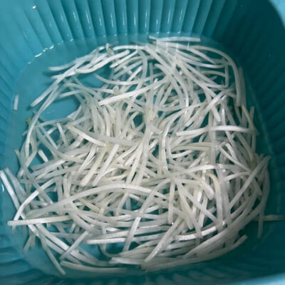 Remove the heads and tails from the mung bean sprouts, and soak in water