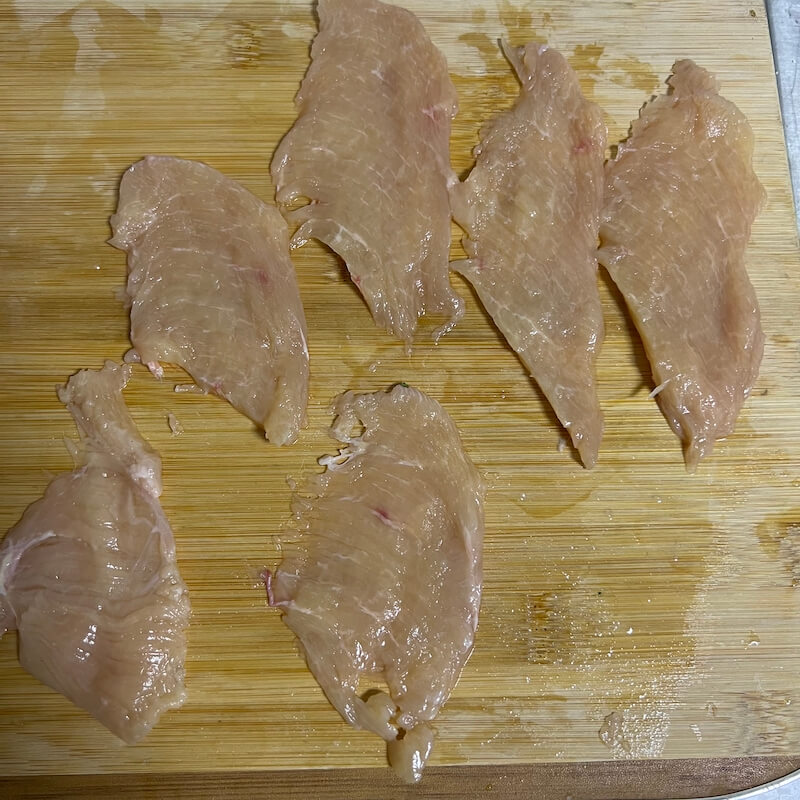remove the skin and fat from the chicken breast. Then we press the chicken breast with our left hand, and use a knife with our right hand to cut from the bottom of the chicken breast, dividing a chicken breast into 6-7 thin slices.
