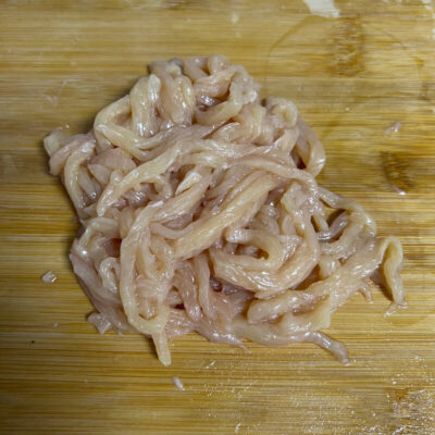 In the third step, we shred the sliced chicken breast and shred it according to its texture. Cut across the grain.