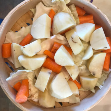 Cut the potatoes and carrots into small chunks. Layer the bottom with leaves of fresh cabbage.