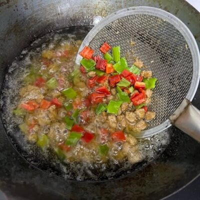 Add the red and green peppers, and blanch for four seconds, then remove all ingredients and drain the oil