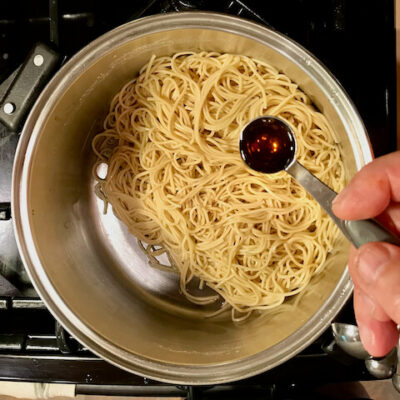 Add sesame oil to the noodles and toss to combine.