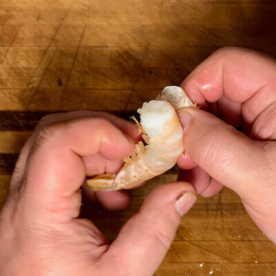 Peel the shrimp by grasping the feet and unwrapping the shell.