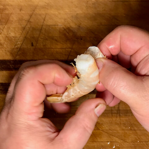 Peel the shrimp by grasping the feet and unwrapping the shell.