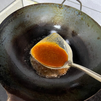 Add the 甜面酱 (tiánmiànjiàng) sweet bean sauce to the wok.