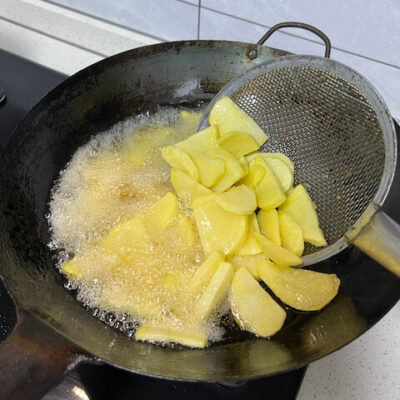 Fry the potato slices in hot oil until golden brown