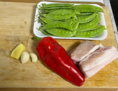 Ginger, garlic, red pepper, pork belly, and snow peas.
