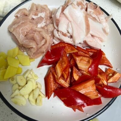 Slice the pork belly, and separate the lean from the fat. Slice the garlic, ginger, and red pepper.