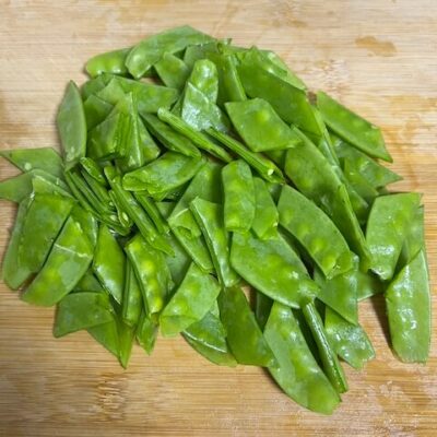 Trim the ends off the snow peas, and cut in half.