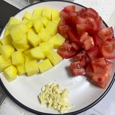 Cut the potato and tomato into cubes, mince the garlic