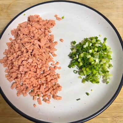 Mince the ham sausage and chop the green onions