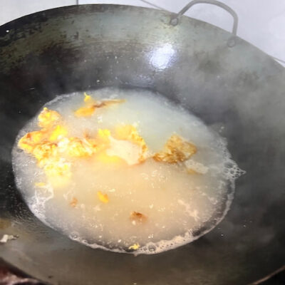Pour 450 ml of 80 degree water into the wok with the egg