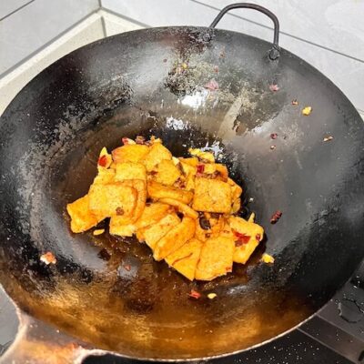 toss the tofu in the doubanjiang to coat evenly