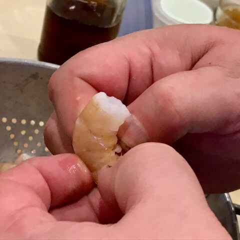 Grasp the shrimp flippers and peel