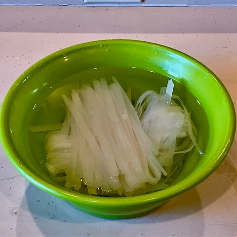 将干面在热自来水中浸泡 30 分钟,然后放入沸水中煮 30 秒。 倒掉水,用冷自来水彻底冲洗面条,去除淀粉,防止结块,然后放在筛子里晾干,同时加热炒锅。