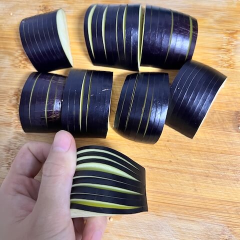 Make seven partial slices across the eggplant, about 5 mm (3/16 in) wide. On the 8th slice, cut completely through the eggplant